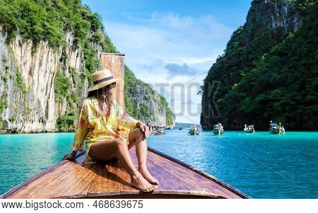 Asian Women In Front Of A Longtail Boat At Kho Phi Phi Thailand At Pileh Lagoon With Turqouse Water