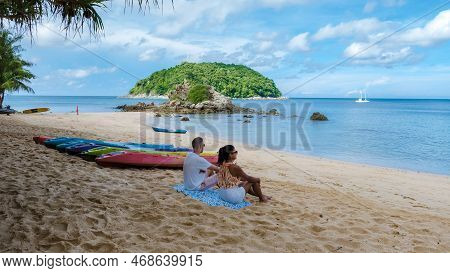 Couple At Yanui Beach Phuket Thailand With Kayaks On The Beach, Tropical Beach With The Blue Ocean