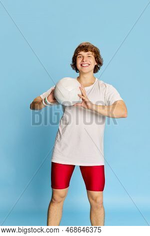 Young Happy Cheerful Man In Sportswear With Volleyball Ball Isolated Over Blue Background. Concept O