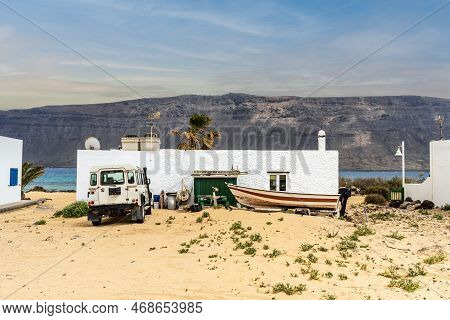 Caleta Del Sebo Cityscape - Sandy Roads, 4x4 Car, Boat And White Houses With Volcanic Lanzarote Isla