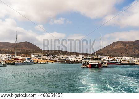 Caleta Del Sebo, Spain - April 30, 2022: Small Harbor With Touristic Ferries Commuting People Betwee