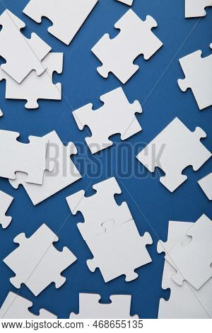 Uncompleted Elements Of A White Puzzle On Blue Background. Vertical Photo