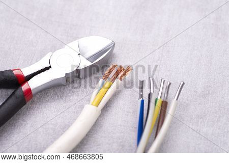 Electric Cables Without Insulation And Wire Cutters On A Gray Table
