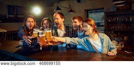 Group Of Young People, Men And Women, Fans Emotionally Cheering Up Favourite Sport Team At The Pub. 