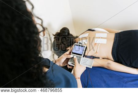 View Of Physiotherapist Electrostimulating A Patient. Lower Back Therapy With Electrode Pads. Electr
