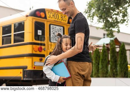 Parent Taking Child To School. Pupil Of Primary School Go Study With Backpack Outdoors. Father And S