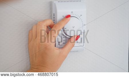 Woman Hand Adjusts Or Turns On Wall Temperature Controller Controller Button. Climate Control In Roo