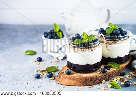 Parfait With Blueberry, Granola And Jam In Two Glass Jars. Healthy Dessert Or Snack.