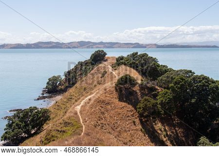 The View Of Picturesque Landscape With Hiking Trail, Dry Grass Slope And Blue Sea On Background In A