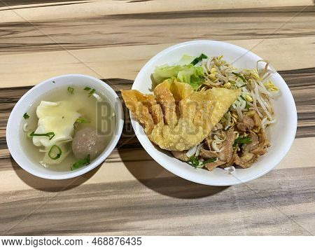 Mie Ayam Noodles Chicken With Topping Meats And Vegetables With Wooden Table Background Or Texture.