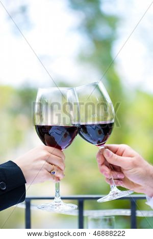 Clink con bicchieri di vino rossi all'esterno sulla terrazza, un ristorante raffinato