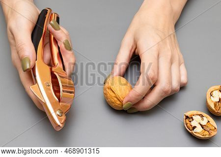 Man Cracking A Walnut With A Nutcracker. Man Cracking A Nut. Nut Cracker