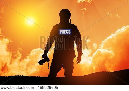 Photojournalist Silhouette Documenting War Or Conflict. Photojournalist At Sunset. War, Army, Techno