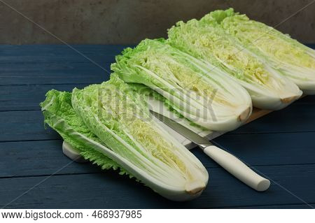 Cut Fresh Ripe Chinese Cabbages On Blue Wooden Table