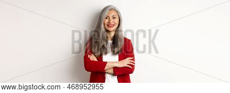 Business People. Smiling Asian Senior Woman In Red Blazer, Cross Arms On Chest And Looking Professio