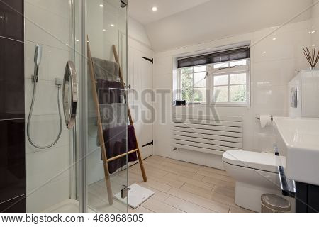 Kennett, Suffolk, England - March 1 2019: Modern Luxury White Tiled Shower Room With Wooden Towel Ra