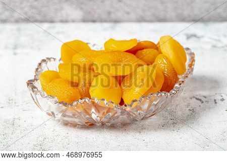 Dried apricots on stone background. Dark dried apricots in a glass bowl. Diet foods. close up