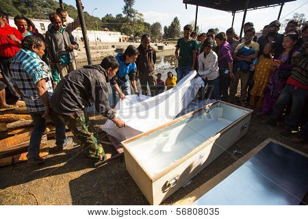 KATHMANDU, NEPAL - DEC 3: Unidentified local people during the cremation ceremony along the holy Bagmati River in Bhasmeshvar Ghat at Pashupatinath temple, Dec 3, 2013 in Kathmandu, Nepal.