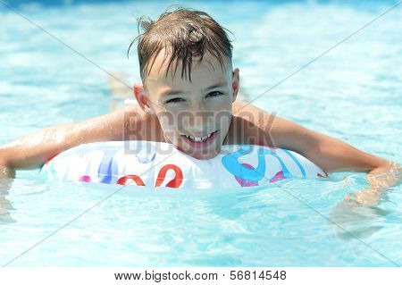Happy teenage boy sweeming in pool