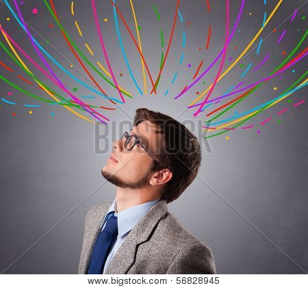 Young man standing and thinking wiht colorful abstract lines overhead