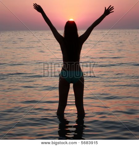 Freedom - girl in a sea at sunset