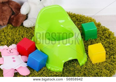 Green potty on home interior background