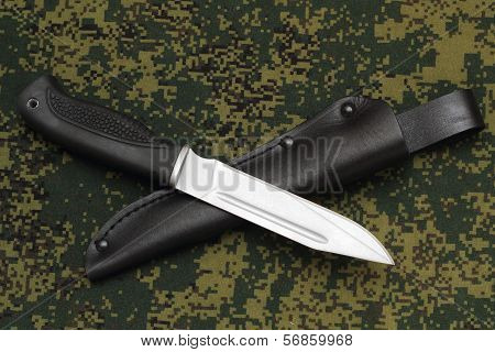 Military Knife Lying Across Black Leather Sheath On  Camouflage Background