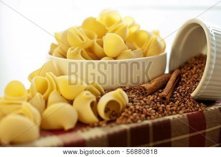 White Porcelain Plates With Dry Snailshell-shaped Pasta And Buckwheat