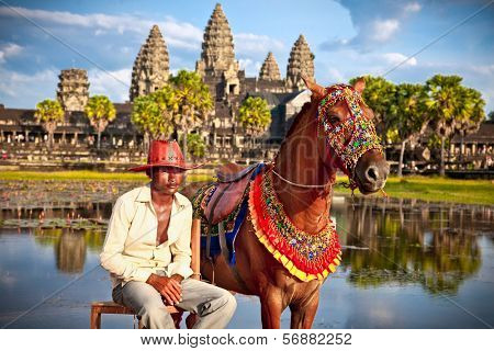  ANGKOR WAT, CAMBODIA - NOV  20,2013: Unidentified man and horse for rent in Angkor Wat conplex on Nov 20, 2013, Cambodia. Angkor temples and ruins are UNESCO World Heritage Site.