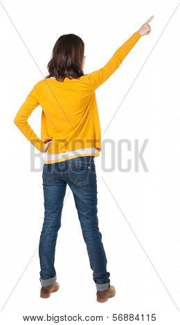 Back view of  pointing woman. beautiful brunette  girl in yellow pullover. Rear view people collection.  backside view of person.  Isolated over white background.