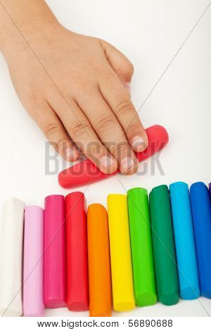 Child hand with colorful modeling clay bars