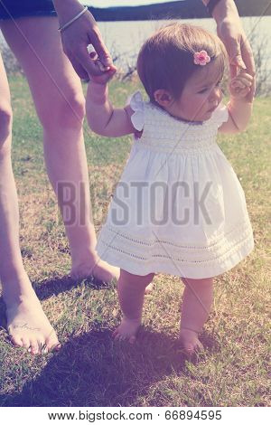 Mother teaching baby girl how to walk