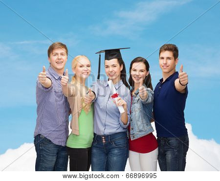 education and people concept - group of standing smiling students with diploma and corner-cap showing thumbs up