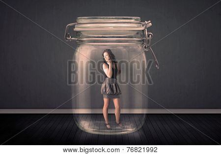 Businesswoman trapped into a glass jar concept on background