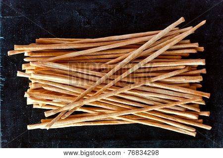 top view of breadsticks grissini torinesi on blackboard background