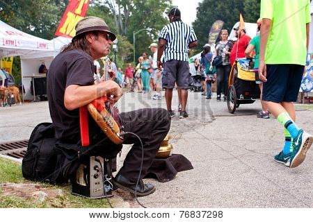 Man Strums Bass Guitar For Tips At Arts Festival