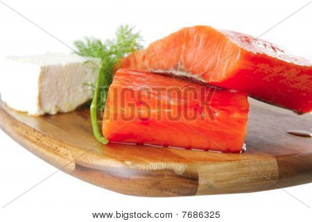 Rose saumon sur une plaque en bois avec du fromage