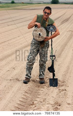 Kiev,Ukraine.June 3.Military archeology. Man with metal detector and German WWII anti tank landmine.At June 3,2012 in Kiev, Ukraine 