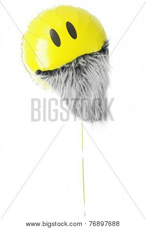 A yellow mylar balloon with two eyes and a furry gray beard.  On a white background.