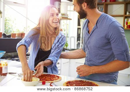 Young Couple Making Pizza In Kitchen Together