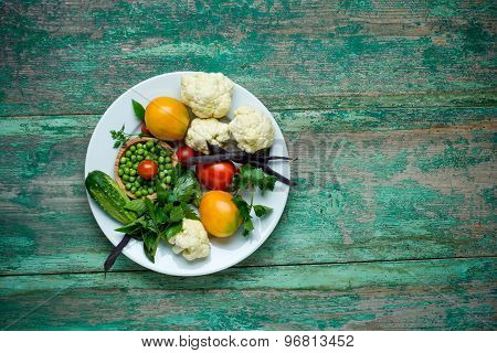 Vegetables . Fresh Bio Vegetable on a plate. Over wooden background