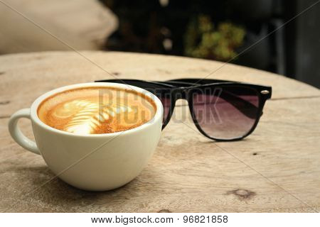 Coffee With Sunglasses On Background Of Wooden.