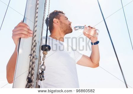Nice man drinking water on yacht