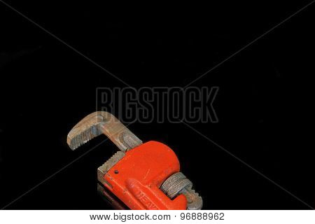 Large Adjustable Wrench With Red Handle Isolated On Black