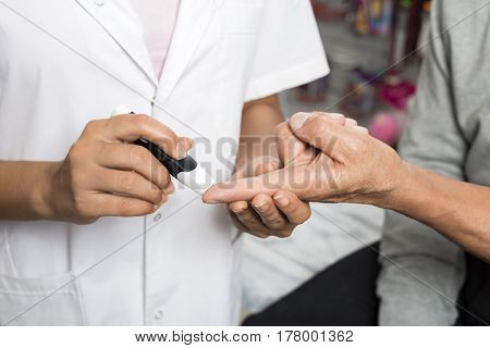 Female Doctor Checking Sugar Level Of Patient With Glucometer
