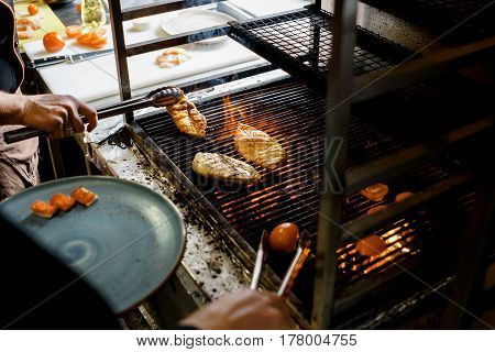 Cooks grilled steak meat food on fire
