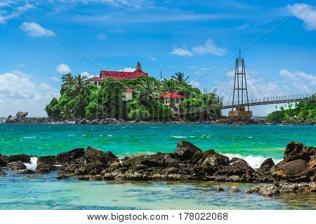 Buddha Temple in Matara island of Sri Lanka. Beautiful tropical beach white sand turquoise ocean water and blue sky.