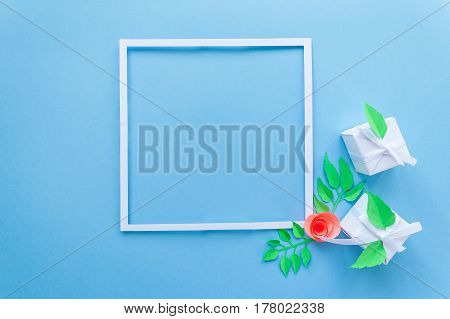 Square Frame With White Gift With Paper Flower On Blue Background