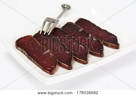 Dried beef basturma, chopped with fork. Studio Photo