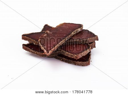 Dried beef basturma, chopped on white. Studio Photo